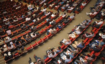 The United States presents a complex social reality event venue, auditorium, meeting, forum, conference, listener, audience, public, people, sit, watching